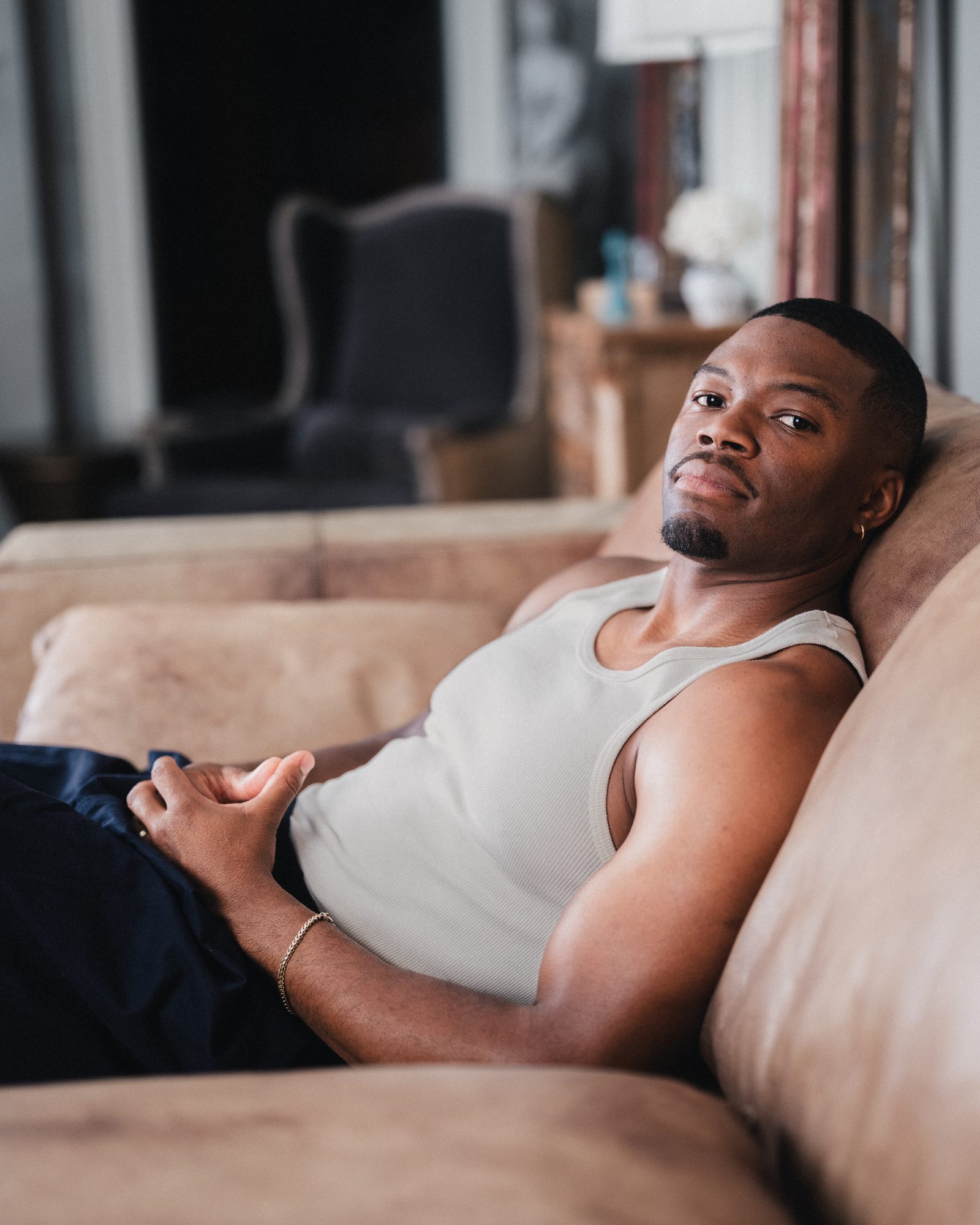 Caleb Castille reclining on a couch in a tank top