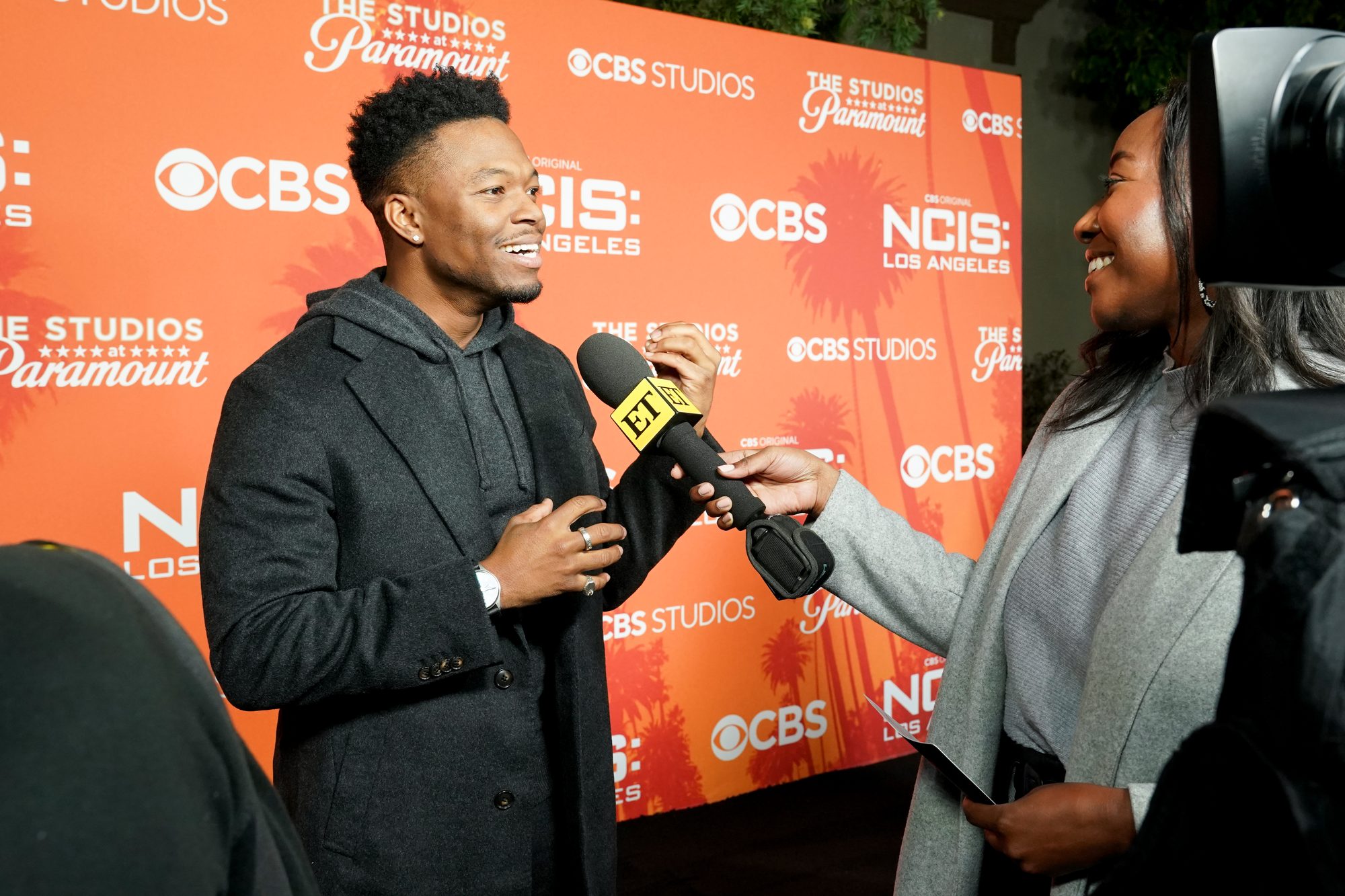 Caleb Castille being interviewed in front of a CBS, NCIS: Los Angeles and The Studios at Paramount backdrop